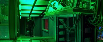 Movie still from “Mission: Impossible II” (2000), directed by John Woo – A man standing next to an electrical box in a building; Wide shot, Low angle