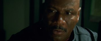 Movie still from “Mission: Impossible II” (2000), directed by John Woo – A man's face in the dark; Close Up shot, High angle