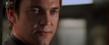 Movie still from “Mission: Impossible II” (2000), directed by John Woo – A man's face in a dark room; Close Up shot, Low angle