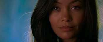 Movie still from “Mission: Impossible II” (2000), directed by John Woo – A woman's face with long black hair; Close Up shot, High angle