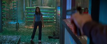 Movie still from “Mission: Impossible II” (2000), directed by John Woo – A woman standing in the middle of a room; Wide shot, Low angle