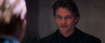 Movie still from “Mission: Impossible II” (2000), directed by John Woo – A person wearing a black shirt; Close Up shot, Over the shoulder angle