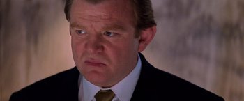 Movie still from “Mission: Impossible II” (2000), directed by John Woo – A person wearing a suit and tie; Close Up shot, Low angle