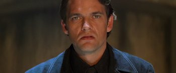 Movie still from “Mission: Impossible II” (2000), directed by John Woo – A person wearing a suit and tie; Close Up shot, Low angle