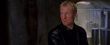 Movie still from “Mission: Impossible II” (2000), directed by John Woo – A person wearing a black leather jacket; Close Up shot, Low angle