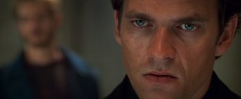 Movie still from “Mission: Impossible II” (2000), directed by John Woo – A man's face with blue eyes; Close Up shot, Over the shoulder angle