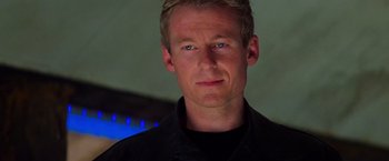 Movie still from “Mission: Impossible II” (2000), directed by John Woo – A person wearing a black shirt; Close Up shot, Over the shoulder angle