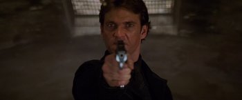 Movie still from “Mission: Impossible II” (2000), directed by John Woo – A man is holding a gun in his hand; Close Up shot, Low angle