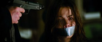 Movie still from “Mission: Impossible III” (2006), directed by J.J. Abrams – A woman with duct tape over her mouth and lips; Close Up shot, Low angle