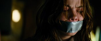 Movie still from “Mission: Impossible III” (2006), directed by J.J. Abrams – A woman with her mouth taped shut; Close Up shot, High angle
