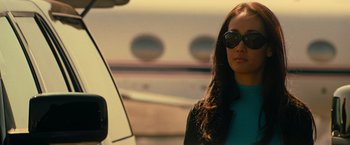 Movie still from “Mission: Impossible III” (2006), directed by J.J. Abrams – A woman wearing sunglasses standing next to a car; Close Up shot, Low angle
