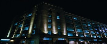 Movie still from “Mission: Impossible III” (2006), directed by J.J. Abrams – A large building lit up at night with windows lit up; Extreme Wide shot, Low angle