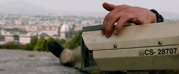Movie still from “Mission: Impossible III” (2006), directed by J.J. Abrams – A man laying on the ground with a box; Extreme Close Up shot, Low angle