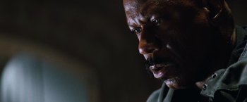 Movie still from “Mission: Impossible III” (2006), directed by J.J. Abrams – An older man with a beard and a mustache looking to his left; Close Up shot, Low angle