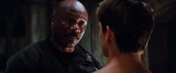 Movie still from “Mission: Impossible III” (2006), directed by J.J. Abrams – A man looking into a mirror while standing next to another man; Close Up shot, Over the shoulder angle