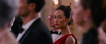 Movie still from “Mission: Impossible III” (2006), directed by J.J. Abrams – A woman in a red dress is standing next to a man in a black suit; Close Up shot, Over the shoulder angle