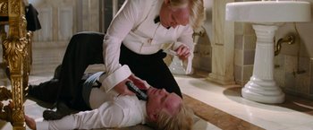 Movie still from “Mission: Impossible III” (2006), directed by J.J. Abrams – A man is lying on the ground while a woman is holding a remote control; Medium shot, Overhead angle