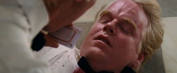 Movie still from “Mission: Impossible III” (2006), directed by J.J. Abrams – A man is laying on the ground with blood all over his face; Close Up shot, Overhead angle