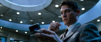Movie still from “Mission: Impossible III” (2006), directed by J.J. Abrams – A man holding a cell phone while wearing a suit and tie; Close Up shot, Low angle