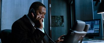 Movie still from “Mission: Impossible III” (2006), directed by J.J. Abrams – A man talking on a phone while holding a cell phone to his ear; Close Up shot, Low angle