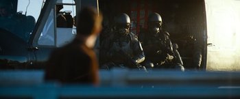Movie still from “Mission: Impossible III” (2006), directed by J.J. Abrams – A group of men in military gear sitting in a room; Wide shot, Over the shoulder angle