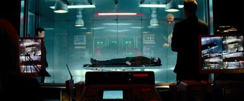Movie still from “Mission: Impossible III” (2006), directed by J.J. Abrams – A man laying on top of a bed in a room; Wide shot, Low angle