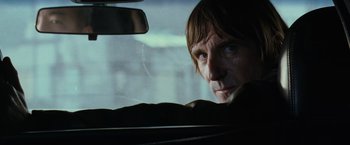 Movie still from “Mission: Impossible III” (2006), directed by J.J. Abrams – A man sitting in the passenger seat of a car looking out the window; Close Up shot, Over the shoulder angle