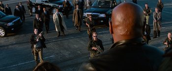 Movie still from “Mission: Impossible III” (2006), directed by J.J. Abrams – A group of people walking down a street with guns; Wide shot, High angle