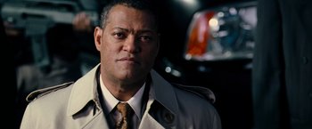 Movie still from “Mission: Impossible III” (2006), directed by J.J. Abrams – A man wearing a trench coat and a tie; Close Up shot, Low angle