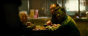 Movie still from “Mission: Impossible III” (2006), directed by J.J. Abrams – A group of people sitting around a table; Medium shot, High angle