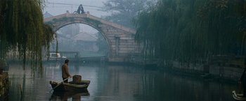 Movie still from “Mission: Impossible III” (2006), directed by J.J. Abrams – A bridge over a body of water with a person standing on top of it; Extreme Wide shot, High angle