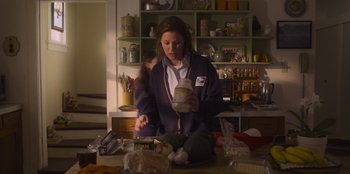 Movie still from “Mixtape” (2021), directed by Valerie Weiss – A woman is holding a jar in her hand; Medium shot, Low angle