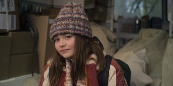 Movie still from “Mixtape” (2021), directed by Valerie Weiss – A young girl wearing a colorful hat and jacket; Close Up shot, Over the shoulder angle