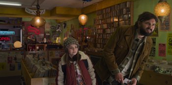 Movie still from “Mixtape” (2021), directed by Valerie Weiss – A young girl in a jacket and a hat in a store; Medium shot, Over the shoulder angle