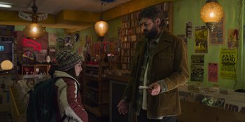 Movie still from “Mixtape” (2021), directed by Valerie Weiss – A man and a woman are talking in a room; Medium shot, Over the shoulder angle