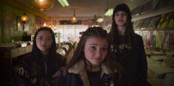 Movie still from “Mixtape” (2021), directed by Valerie Weiss – A group of young people standing next to each other in a room; Medium shot, Low angle