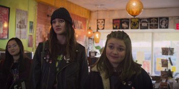 Movie still from “Mixtape” (2021), directed by Valerie Weiss – Two young girls standing next to each other in a room; Medium shot, Over the shoulder angle