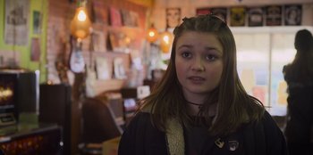 Movie still from “Mixtape” (2021), directed by Valerie Weiss – A young girl is standing in a room; Close Up shot, Over the shoulder angle
