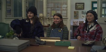 Movie still from “Mixtape” (2021), directed by Valerie Weiss – A group of people sitting around a table; Medium shot, Over the shoulder angle