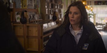 Movie still from “Mixtape” (2021), directed by Valerie Weiss – A woman standing in front of a shelf in a store; Medium shot, Over the shoulder angle