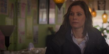 Movie still from “Mixtape” (2021), directed by Valerie Weiss – A woman in a black jacket is standing in a room; Close Up shot, Over the shoulder angle