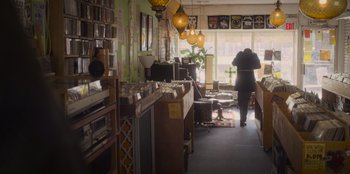 Movie still from “Mixtape” (2021), directed by Valerie Weiss – A person walking down a hallway in a store; Wide shot, Low angle