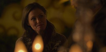 Movie still from “Mixtape” (2021), directed by Valerie Weiss – A woman is looking at a candle in the dark; Close Up shot, Over the shoulder angle