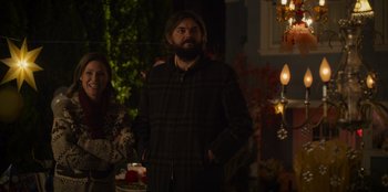 Movie still from “Mixtape” (2021), directed by Valerie Weiss – A man standing next to a woman at a party; Medium shot, Over the shoulder angle