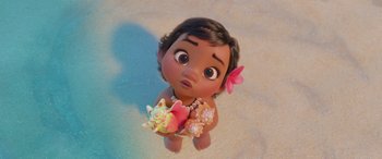 Movie still from “Moana” (2016), directed by Chris Williams – A baby moana is holding a flower in her hands; Medium shot, High angle