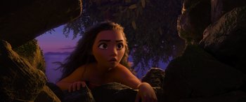 Movie still from “Moana” (2016), directed by Chris Williams – A young girl is sitting on a rock looking up; Medium shot, Low angle
