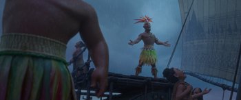 Movie still from “Moana” (2016), directed by Chris Williams – A man in a costume standing on top of a building; Wide shot, Over the shoulder angle