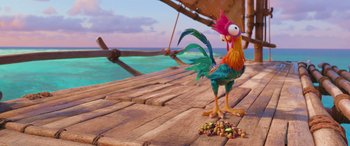 Movie still from “Moana” (2016), directed by Chris Williams – A rooster standing next to a pile of nuts on top of a wooden deck; Wide shot, High angle