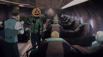 Movie still from “Mobile Suit Gundam: Hathaway” (2021), directed by Shûkô Murase – A person with a pumpkin head stands in front of a row of seats; Wide shot, High angle