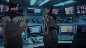 Movie still from “Mobile Suit Gundam: Hathaway” (2021), directed by Shûkô Murase – An animated scene of a man in uniform in front of computer monitors; Medium shot, Over the shoulder angle